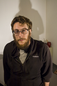 Bearded man wearing glasses in a casual indoor portrait.