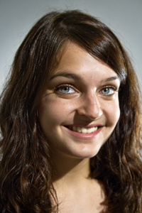 Smiling brunette woman photographed against a neutral background.